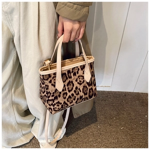 Dettaglio della borsa a secchiello leopardata con finiture in pelle beige e ganci