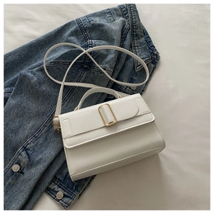Close-up of a white leather crossbody bag with metal buckle and slim shoulder strap
