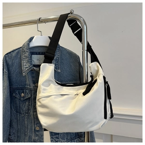 Detail view of the large capacity white nylon crescent bag with black wide shoulder strap