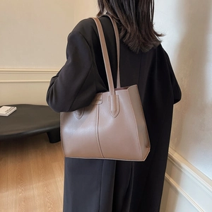 Minimalist tan leather tote bag for women with dual straps and fashion patch detail