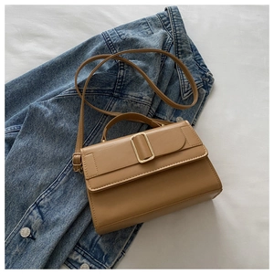 Close-up of a camel square shoulder bag with gold buckle and adjustable strap detail