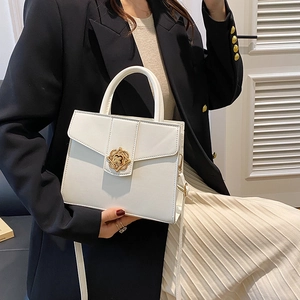 Minimalist white structured handbag with a vintage gold floral lock and leather strap