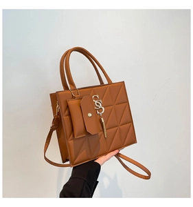 Brown quilted tote bag with triangle stitching and golden letter charm detail