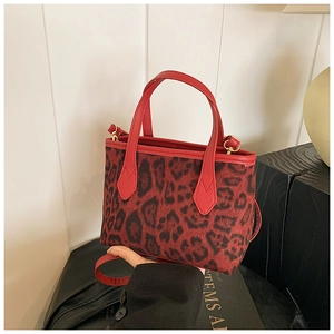 Dettaglio della mini borsa tote leopardata rossa con manici in pelle e finiture oro