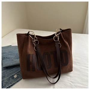 Dettaglio borsa tote in pelle scamosciata marrone con lettere HOTO cucite e catenella