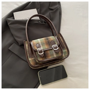 Dettaglio della borsa in lana scozzese retrò con finiture in pelle e fibbie in metallo