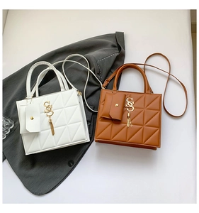 Detail of quilted geometric patterns and gold S-shaped tassels on two leather handbags