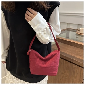 Detailed view of the burgundy nylon shoulder bag with a sleek minimalist texture