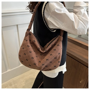 Detailansicht der braunen Cord-Tasche mit schwarzer Schleife und Rautenmuster