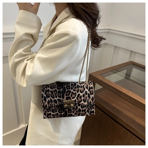Detail of leopard print crossbody bag with gold metal buckle and elegant chain strap