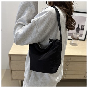 Minimalist black canvas shoulder bag shown on model for daily casual style