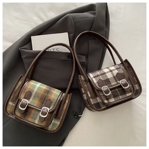 Dettaglio della borsa a quadri in lana vintage con texture scozzese e finiture in pelle