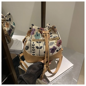 Detalle del bolso saco de tapiz floral con ribete de cuero y bolsillo con cremallera