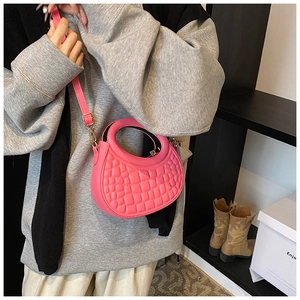 Detail of rose pink crescent bag with geometric embossed texture and hand-held handle