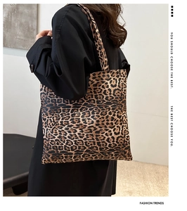 Detailed view of large leopard print tote bag styled on model with black outfit