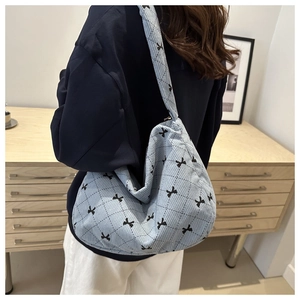 Dettaglio borsa a spalla in velluto azzurro con fiocchi neri e motivo a rombi trapuntato