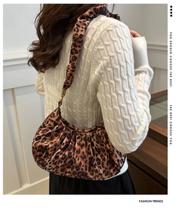 Gros plan du sac léopard avec texture plissée et détail de la boucle en métal doré