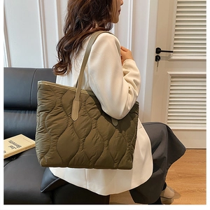Dettaglio della borsa tote trapuntata verde oliva con cuciture eleganti e tracolla sottile