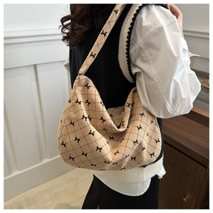 Dettaglio borsa hobo beige in velluto a coste con trapuntatura e fiocchi neri