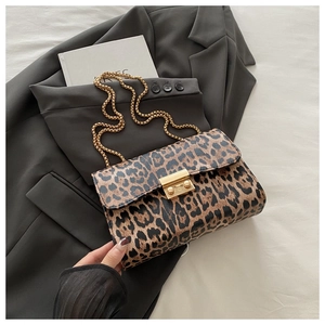Detailed view of the gold chain strap and metal lock on the leopard print shoulder bag