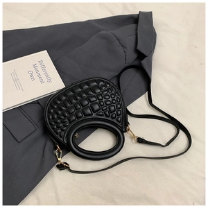 Close-up of black PU leather handbag with 3D bubble texture and round handle detail