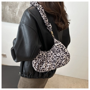Sac hobo léopard avec bandoulière plissée et boucle dorée porté sur l'épaule