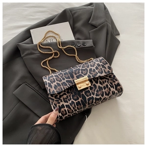 Detail of leopard print bag with gold rectangular clasp and elegant chain strap