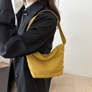 Mustard yellow nylon crescent shoulder bag shown on a model for a casual daily look