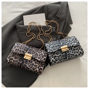 Close-up of leopard print envelope bags with gold chain straps on stylish setting