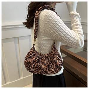 Sac sous le bras plissé à imprimé léopard chic porté avec un pull en maille blanche