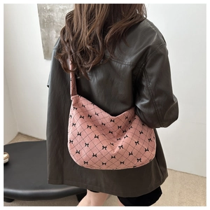 Detail der rosa Cord-Hobo-Tasche mit schwarzem Schleifendruck und Rautensteppung
