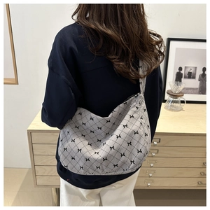 Detail der grauen Cord-Tasche mit schwarzem Schleifenprint und Rautenmuster