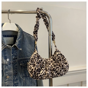 Détail du sac léopard avec texture plissée et boucle en métal doré sur l'épaule