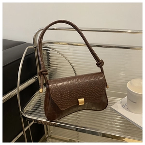 Detail of dark brown faux leather shoulder bag with crocodile pattern and golden square lock