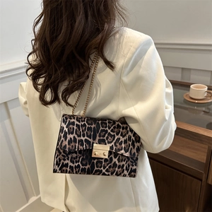 Fashionable leopard print shoulder bag with gold chain strap worn with a white blazer