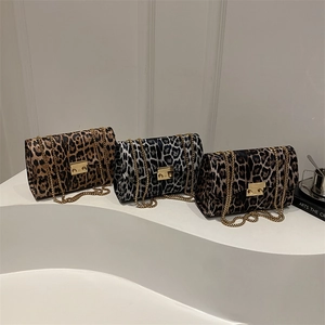 Three leopard print crossbody chain bags in various colors on minimalist white pedestals