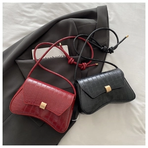 Detail view of crocodile pattern faux leather underarm bags with golden metal buckle