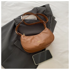 Detail of retro brown hobo bag featuring premium lychee grain leather and gold hardware