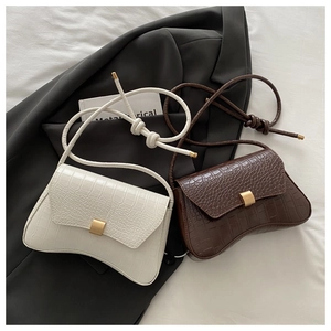 Close-up of white and brown crocodile embossed leather bags with hourglass curved base