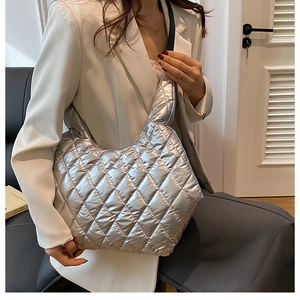 Detail of silver quilted tote bag with metallic sheen and classic diamond stitching texture