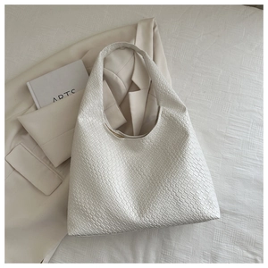 Détail de la texture tressée blanche et du design hobo en croissant du sac fourre-tout