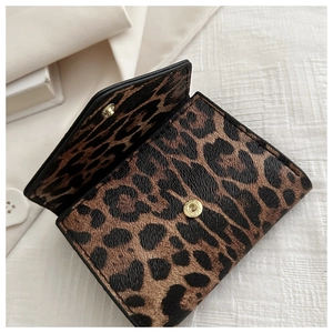 Dettaglio del mini portafoglio leopardato con un bottone automatico metallico dorato