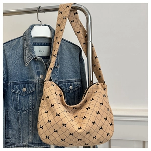 Detailaufnahme der beigen Cord-Einkaufstasche mit Schleifenmuster und Hobo-Design