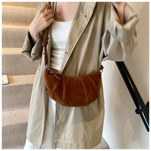 Texture dettagliata della borsa a mezzaluna in camoscio marrone con elegante design a pieghe