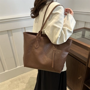 Deep brown large woven leather tote bag with classic textures in a stylish setting