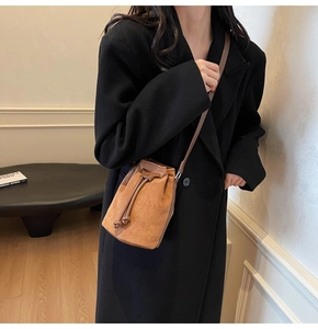 Secchiello minimalista in pelle scamosciata marrone con coulisse indossato a tracolla