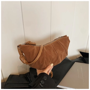 Dettaglio borsa a mezzaluna marrone pieghettata in pelle opaca con nodi decorativi