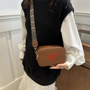 Brown faux leather camera bag with red heart print and geometric wide strap