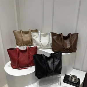 Minimalist woven tote bags in five colors displayed on white stairs for casual daily use