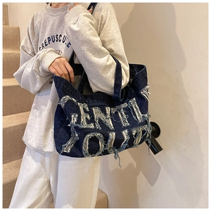 Détail du sac cabas en denim bleu avec inscription Gentle Youth et look style urbain